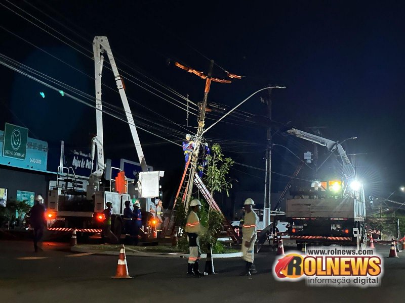 Empresas de energia e internet trabalham na substituição de poste danificado em acidente com caminhão no centro de Rolim de Moura